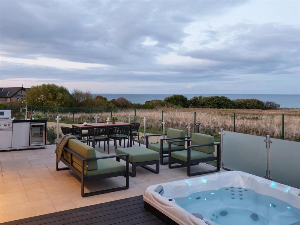 Outdoor terrace with hot tub and sea views
